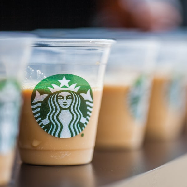 Clear plastic cups with Starbucks logo and coffee beverage samples