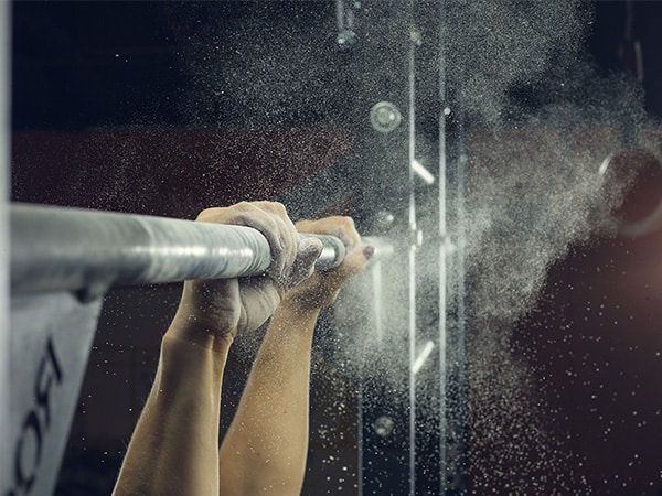 gymnast's hands holding on a bar